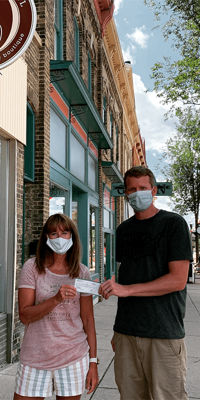 Two people holding checks